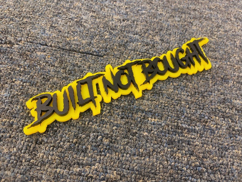 Built Not Bought Car Badge - Matte Black On Yellow - Aggressive Font - Atomic Car Concepts