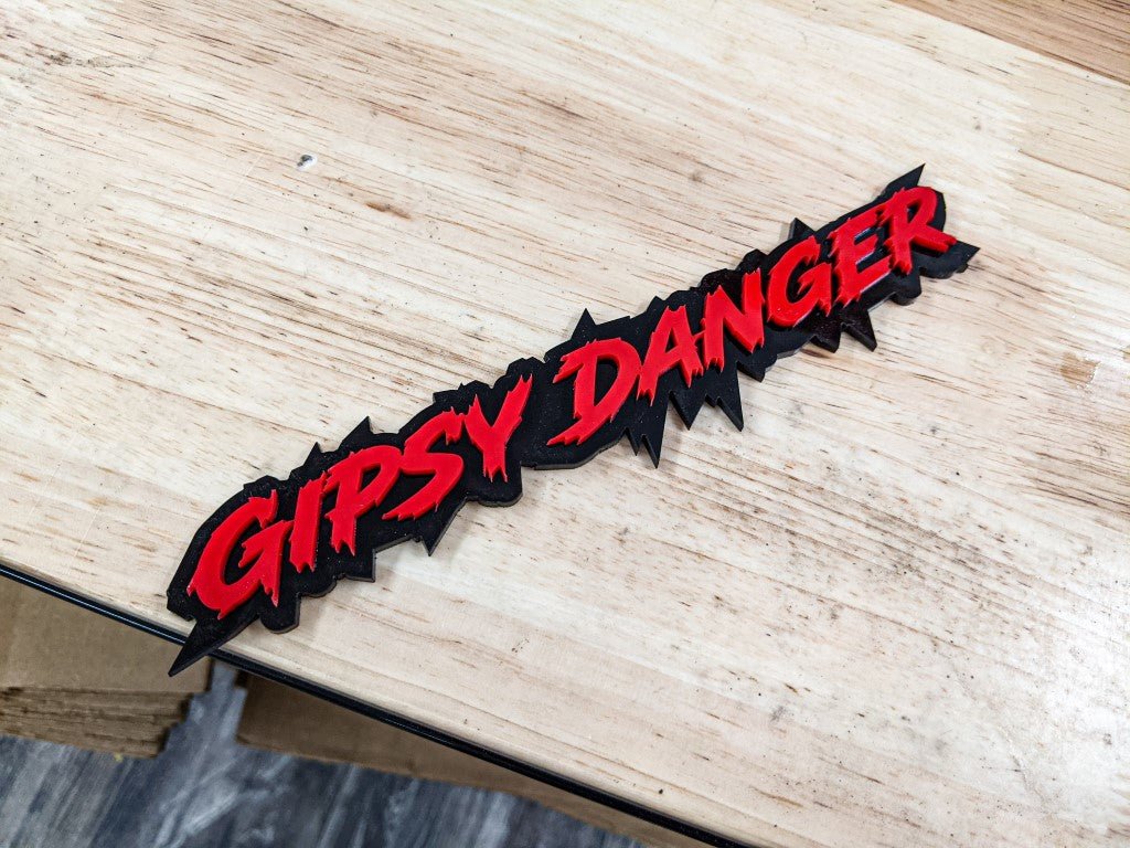 Gipsy Danger Car Badge – Rot auf glänzendem Schwarz – Lightning-Schriftart – Klebebandmontage