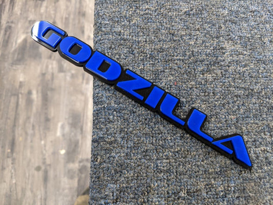 Godzilla Car Badge - Blue On Gloss Black - OEM Font