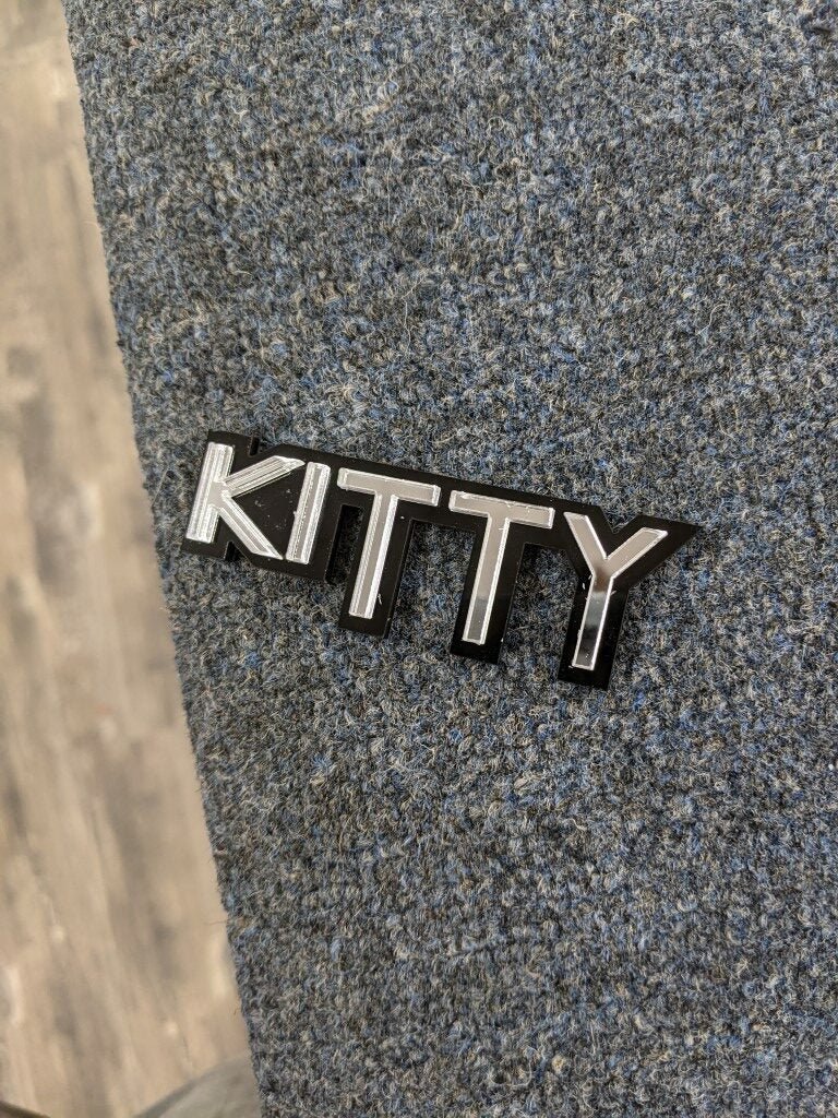 Kitty Car Badge - Brushed Silver On Gloss Black - Squid Font - Tape Mount - Atomic Car Concepts