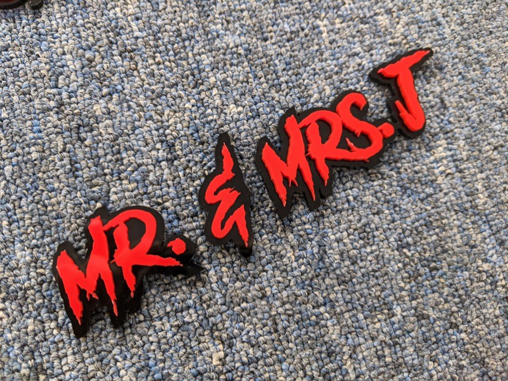 Mr and Mrs J Car Badge - Red on Gloss Black - Aggressive Font - Tape Mounting - Atomic Car Concepts