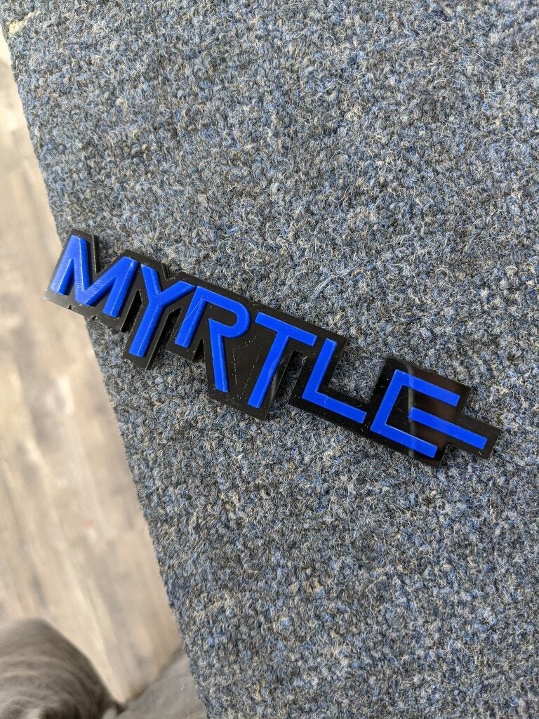 Myrtle Car Badge - Blue On Gloss Black - Squid Font - Atomic Car Concepts