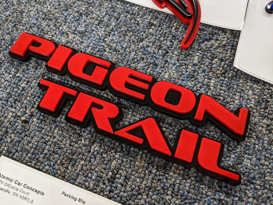 Pigeon Trail Car Badge - Red on Gloss Black - OEM Font - Tape Mounting - Atomic Car Concepts