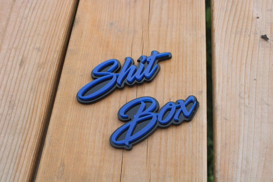 Shit Box Car Badge - Blue On Matt Black - Script Font - Atomic Car Concepts