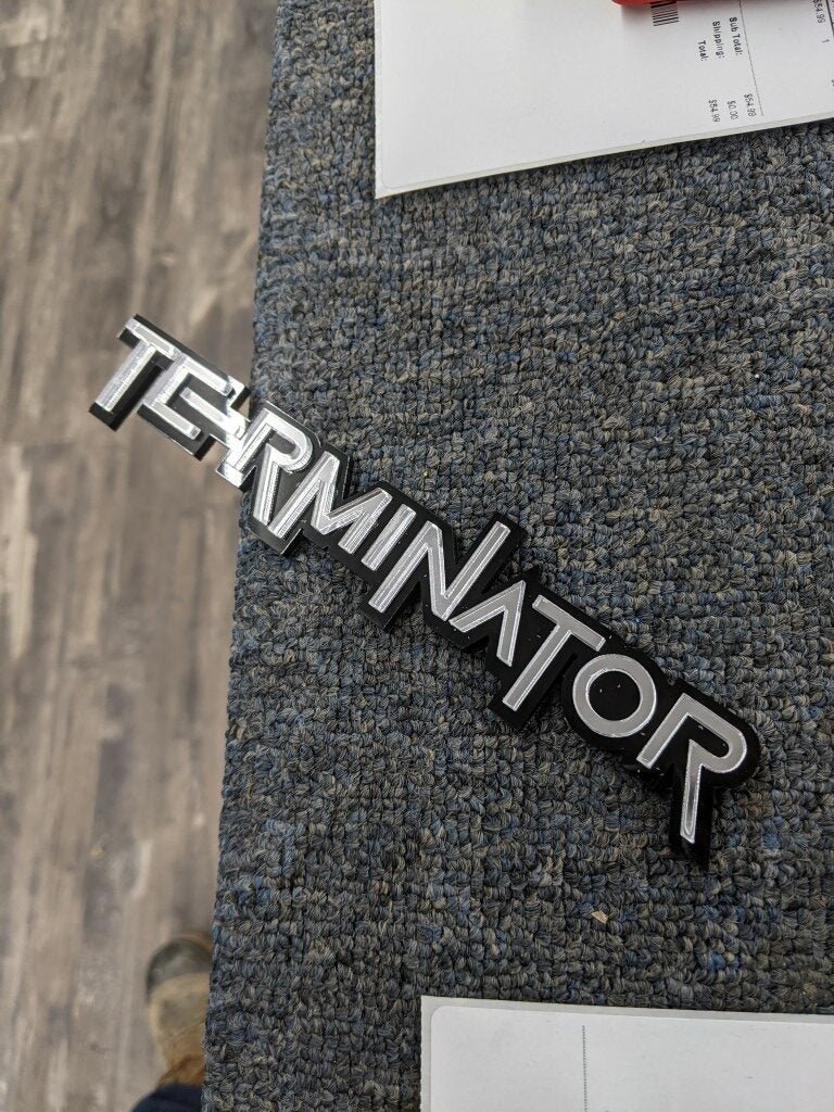 Terminator Car Badge - Mirror Silver On Gloss Black - Squid Font - Tape Mount - Atomic Car Concepts