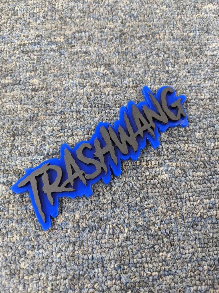 Trashwang Car Badge - Matte Black on Blue - Aggressive Font - Tape Mounting - Atomic Car Concepts